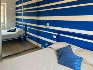 una camera da letto con parete a righe blu e bianche di La Casa di Chiara a La Spezia