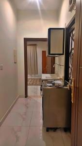 a room with a desk and a television on a wall at جوهرة العزيزية للشقق المفروشة in Medina