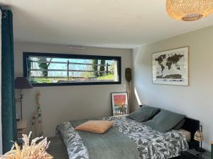 a bedroom with a bed and a window at Le Cottage de l'Albâtre Gîte 2 pers jardin parking 6 kms Etretat Yport in La Forge