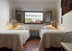 two beds in a room with a window at Casa Pier in Altea