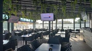 a dining room with tables and chairs and a screen at Star Hotel in Tulcea