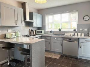uma cozinha com armários brancos e uma bancada em 4Bed Home MK em Shenley Brook End
