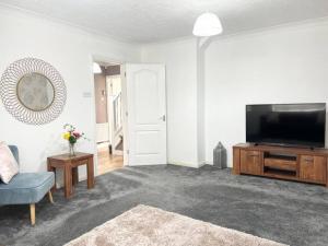 a living room with a flat screen tv and a couch at 4Bed Home MK in Shenley Brook End