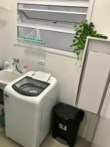 a small bathroom with a toilet and a sink at Ubatuba Apto Encantador in Ubatuba