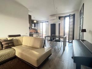 ein Wohnzimmer mit einem Sofa und einem Esszimmer in der Unterkunft Design Villa-Milano & Rho fiera in Sedriano