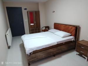 una camera con letto in legno e cassettiera in legno di rainfort apart nikfer 