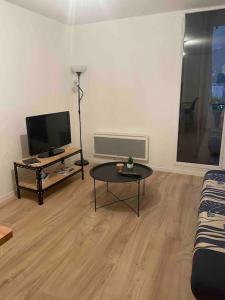 a living room with a tv and a coffee table at Studio lumineux - Départs de randonnées in Laruns