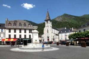 a town with a clock tower in the middle of a street at Studio lumineux - Départs de randonnées in Laruns