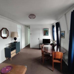 エトルタにあるL'Arche, appartement sur les toits d'Etretatのテーブルと椅子のあるリビングルームと部屋