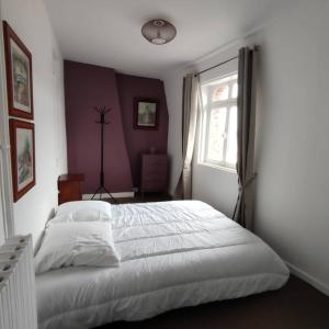 エトルタにあるL'Arche, appartement sur les toits d'Etretatの白いベッドと窓のある寝室