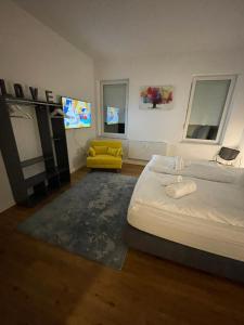 a bedroom with a large bed and a yellow chair at WEN BHF NEU & ZENTRAL in Weiden für bis zu 6 Personen in Weiden