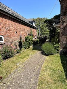 een stenen huis met een bakstenen pad ervoor bij The Old Barn Throop. Spacious Barn conversion. in Bournemouth