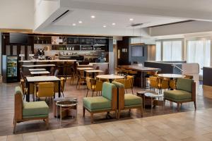 a restaurant with tables and chairs and a bar at Courtyard by Marriott Rye in Rye