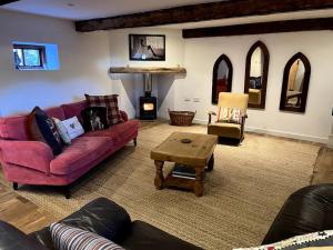 a living room with two couches and a table at The Old Barn Throop. Spacious Barn conversion. in Bournemouth
