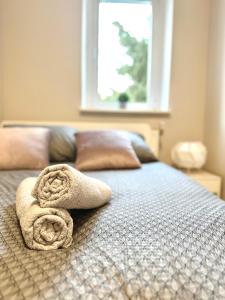 łóżko z ręcznikami na górze z oknem w obiekcie MMRent Plant Room w Gdańsku