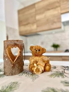 een bruine teddybeer naast een houten stomp bij Luminoso in centro paese in Carona