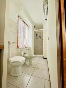 een witte badkamer met een toilet en een wastafel bij Luminoso in centro paese in Carona