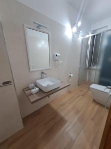ein Badezimmer mit einem Waschbecken, einem WC und einem Spiegel in der Unterkunft Villa Andres in Sassari