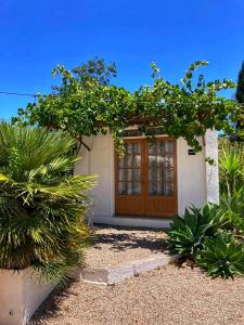 una casa con una puerta de madera y algunas plantas en Finca Serrato, en Colmenar