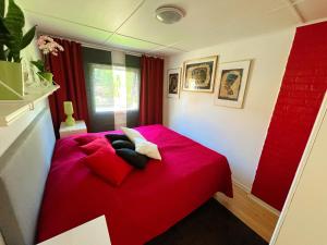 a red bed with two pillows on it in a room at Lovely cottage by the south coast in Trelleborg