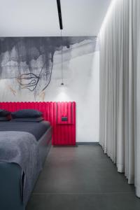 a bedroom with a red bed and white curtains at Eagle's Nest Ljubljana in Ljubljana