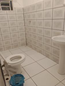 a white bathroom with a toilet and a sink at Pousada Acalanto in Pirenópolis