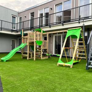 a playground with two play equipment on a lawn at The Residence Apeldoorn in Apeldoorn +49 photos