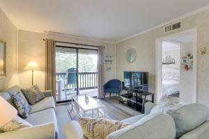 a living room with a couch and a television and a bed at Hilton Head Condo with Balcony and Pool, Walk to Beach in Hilton Head Island