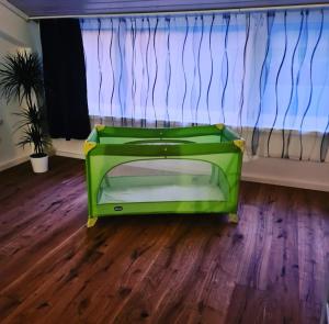 ein grünes Bett in einem Zimmer mit Fenster in der Unterkunft Muota River & Industry Apartment by Nature Apartments Switzerland in Muotathal