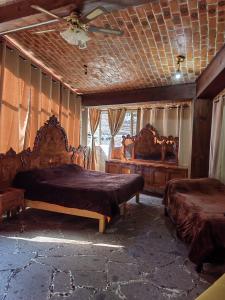 a bedroom with two beds and a ceiling fan at LA CASA DE LOS MANGOS AJIJIC in San Antonio