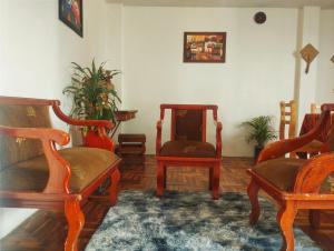 uma sala de estar com duas cadeiras e um tapete em Villa bonita em Baños