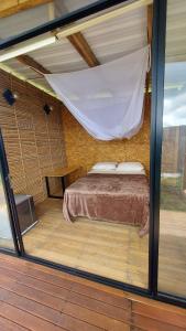 Schlafzimmer mit einem Bett mit Moskitonetz in der Unterkunft COCOZNA Glamping in Norcasia