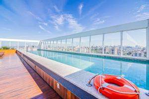 um barco vermelho sentado à beira de uma piscina num edifício em Apto com otima localizacao em Azenha-Porto Alegre em Porto Alegre