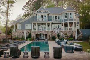 a house with a swimming pool in front of a house at The Ritz-Carlton Reynolds, Lake Oconee in Turnwold