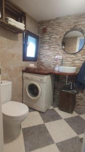 a bathroom with a washing machine and a sink at Casa Monte Los Peñasquitos in Cazalla de la Sierra