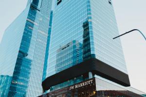 un grand bâtiment en verre avec un panneau devant lui dans l'établissement JW Marriott Edmonton ICE District, à Edmonton