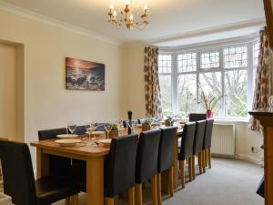 a dining room with a long table and chairs at Ryndle Corner in Scarborough