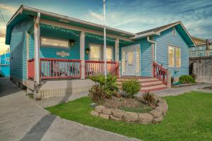 une maison bleue avec une terrasse couverte et une cour dans l'établissement Beachside Getaway - 77 Steps To The Sand, à Galveston