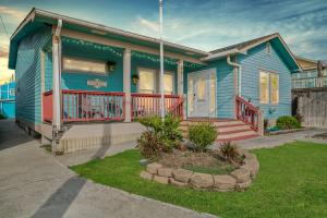 a blue house with a porch and a yard at Serene Beachside Getaway - 77 Steps To The Ocean in Galveston