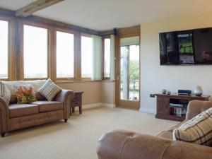 a living room with two couches and a flat screen tv at The Grange in Dinmore
