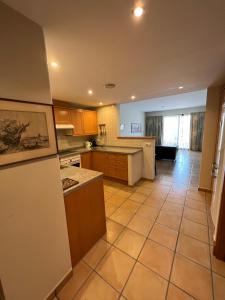 uma cozinha com armários castanhos e piso em azulejo em Apartamento Alfaz Del Sol em L'Alfàs del Pi