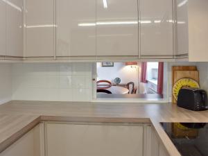 a kitchen with white cabinets and a counter top at The Bothy in Old Hutton