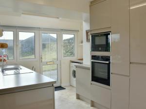 a kitchen with a sink and a stove top oven at The Bothy in Old Hutton