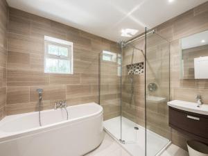 a bathroom with a tub and a shower and a sink at Beech Cottage - Uk11845 in Saltash