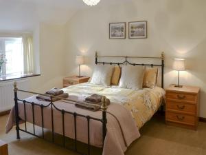 a bedroom with a bed with two night stands and two lamps at Dunstanburgh View in Craster