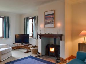 Arduaine的住宿－Tigh An Aighear，客厅设有壁炉和电视。