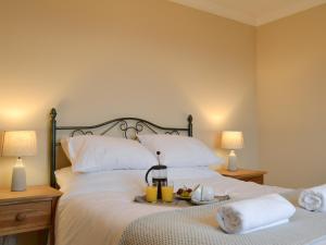 Arduaine的住宿－Tigh An Aighear，一间卧室配有一张带白色床单和两盏灯的床。