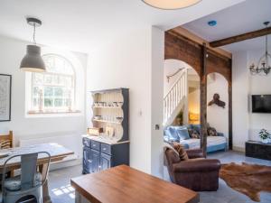 ein Wohnzimmer mit einem Esstisch und ein Wohnzimmer mit einer Treppe in der Unterkunft Tack Room in Benniworth