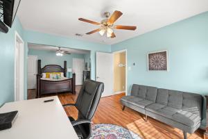 - un salon avec un canapé et un ventilateur de plafond dans l'établissement Beachside Getaway - 77 Steps To The Sand, à Galveston