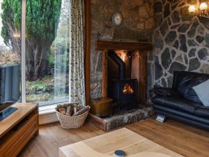 a living room with a fireplace in a stone wall at Janvalyn in Tregarth